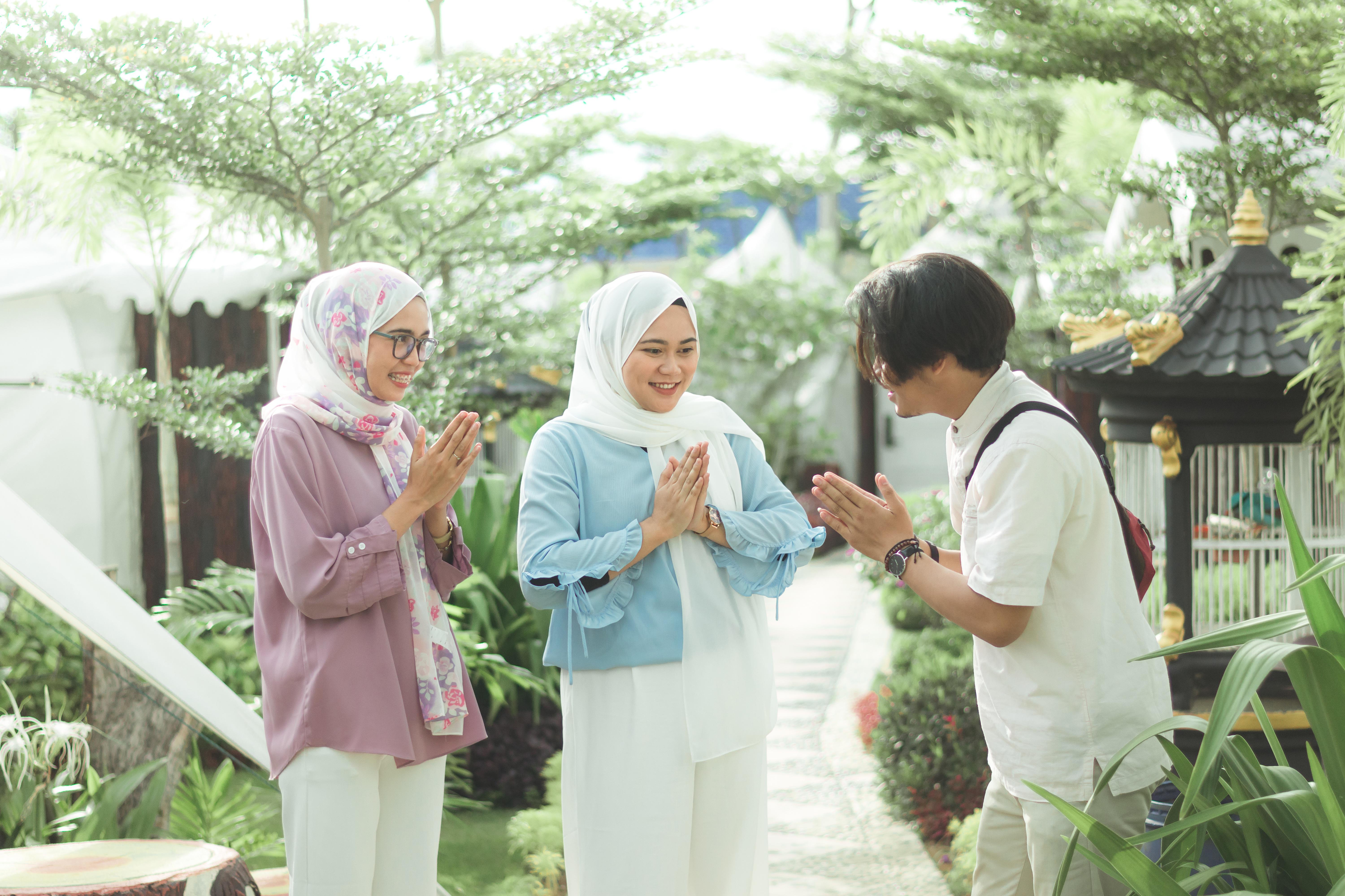 Three friends greeting one another with palms pressed together